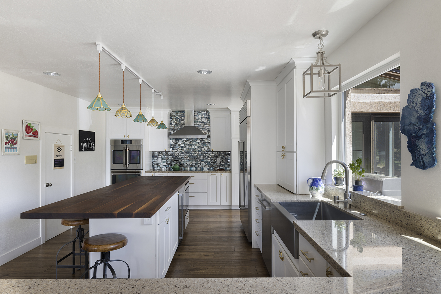 Chef’s kitchen at Kinpine House: island with a butcher-block counter, the sink, double ovens and the range hood
